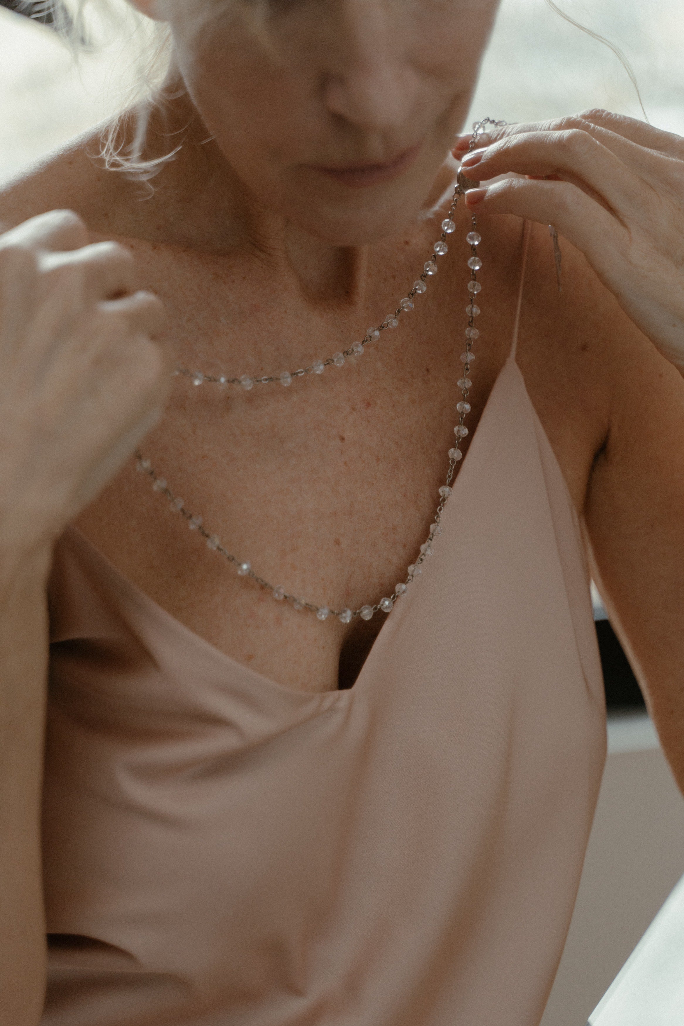 Woman wearing a delicate gemstone necklace. Handmade in USA. Baba Jewelry.